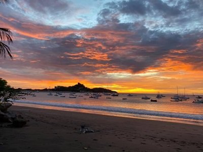 Webcam view of a vivid orange and yellow sunset over the Playa Flamingo marina in Costa Rica.