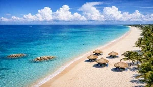 Live view looking down at the beach and palapas at the Casa del Mar Resort in Aruba.