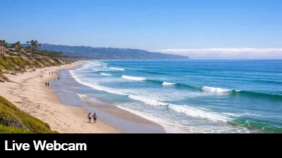 Live view of Del Mar beach and surf looking towards La Jolla with the marine layer hugging the coast.