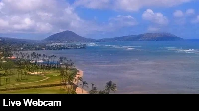 Beautiful view of the coastline's breaking waves and lush, green vegetation at the base of Diamondhead in Oahu, Hawaii.