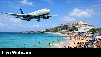 A Boeing 767 passes just feet above a populated beach in beautiful St Maarten.