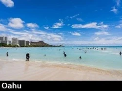 View from the sand and turquoise colored water at Waikiki beach with Diamondhead in the background