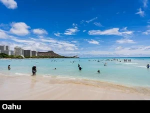 View from the sand and turquoise colored water at Waikiki beach with Diamondhead in the background