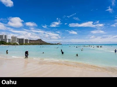 View from the sand and turquoise colored water at Waikiki beach with Diamondhead in the background