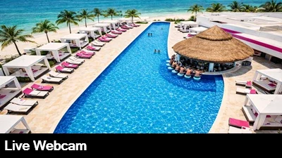 Live view from the top of the Temptation Cancun looking down on the pool, bar and cabana area with the beautiful Caribbean and boats moored next to the beach.