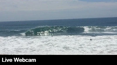 Live look at huge waves as they compress and rise adjacent to the rocky jetty.