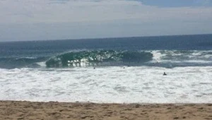 Live look at huge waves as they compress and rise adjacent to the rocky jetty.