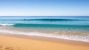 Live close up view of the sand and surf at Waimea Bay in Oahu, Hawaii as surfers wait their turn.